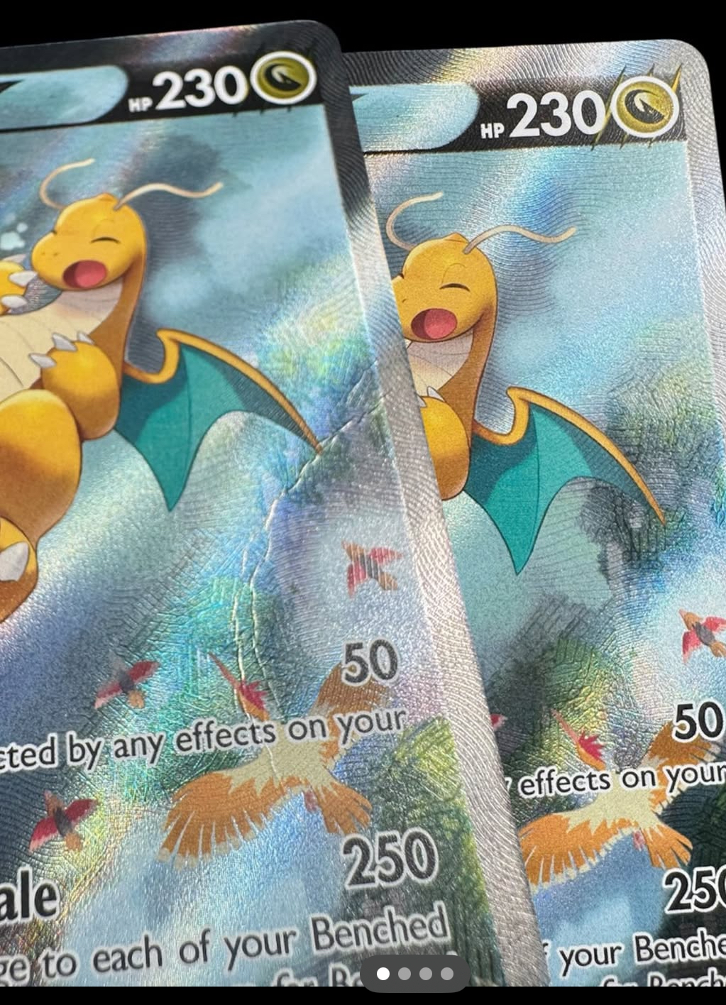 Deux cartes Pokémon Dracolosse holographiques : l'une marquée par une pliure, l'autre remise en état